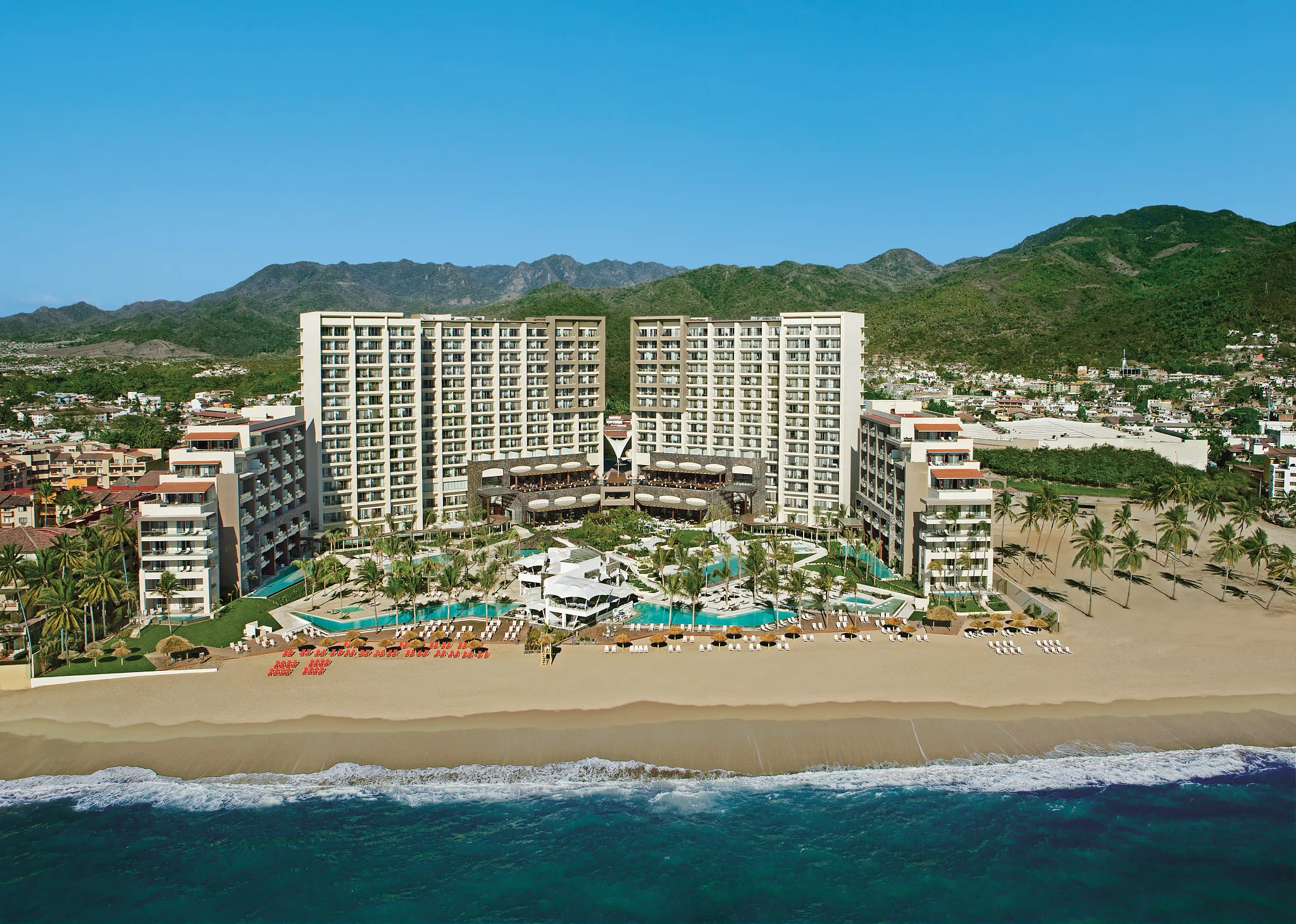 Aerial view of Secrets Vallarta Bay Puerto Vallarta beachfront resort with pools, palm trees, and golden sand along the Pacific coast.