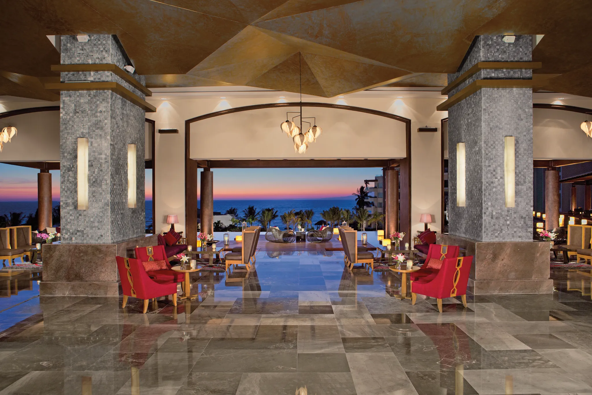 Elegant open-air lobby with ocean views at sunset at Secrets Vallarta Bay Puerto Vallarta, featuring modern design and luxury seating.