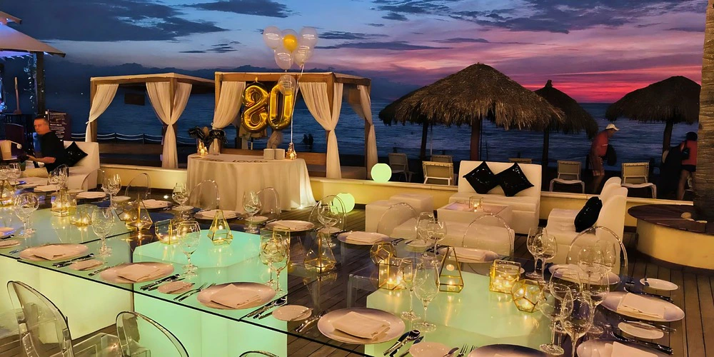 Pool deck wedding reception with illuminated table and ocean sunset views at Secrets Vallarta Bay Puerto Vallarta
