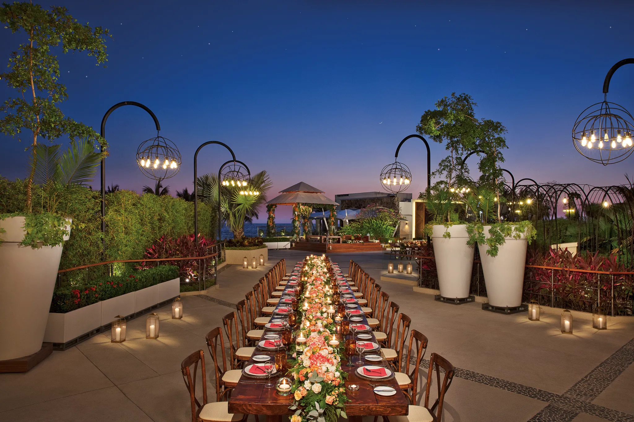 Long banquet reception table with candles and floral arrangements at Vista Terrace at Secrets Vallarta Bay Puerto Vallarta